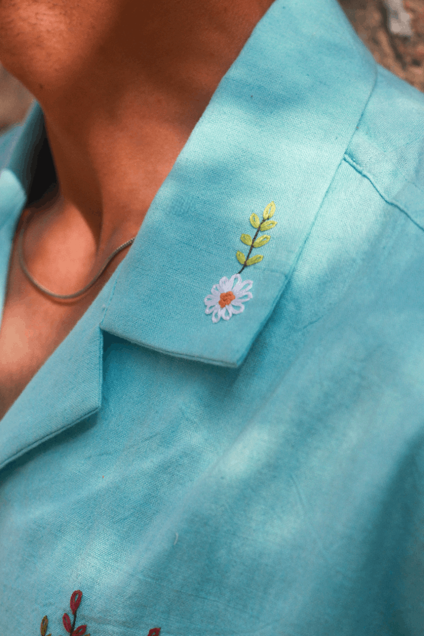 Close-up of Cuban collar with hand embroidered daisy detail, aqua blue handloom cotton men's shirt