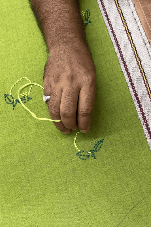 Artisan hand embroidering the lemon motifs, the making of the Florence Embroidered Shirt by Oje'