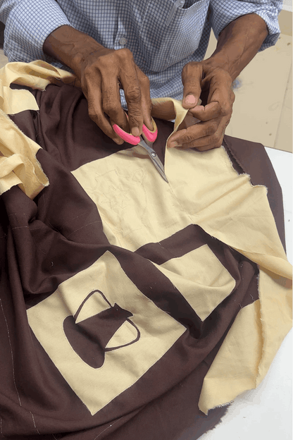 Artisan hand embroidering the pottery appliqué, the making of the Ajanta Applique Shirt by Oje'