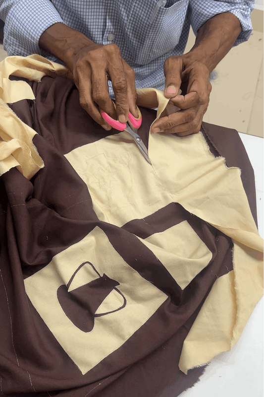 Artisan hand embroidering the pottery appliqué, the making of the Ajanta Applique Shirt by Oje'