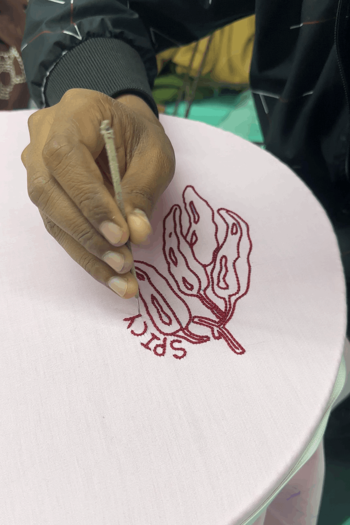 Artisan hand embroidering the chilli motif, the making of the Mexico Embroidered Shirt by Oje'