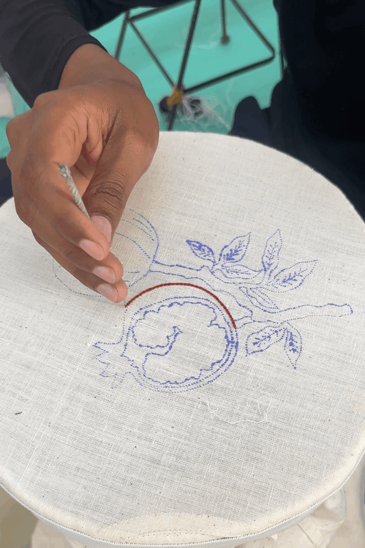 Artisan hand embroidering the pomegranate motif, the making of the Mersin Embroidered Shirt by Oje'