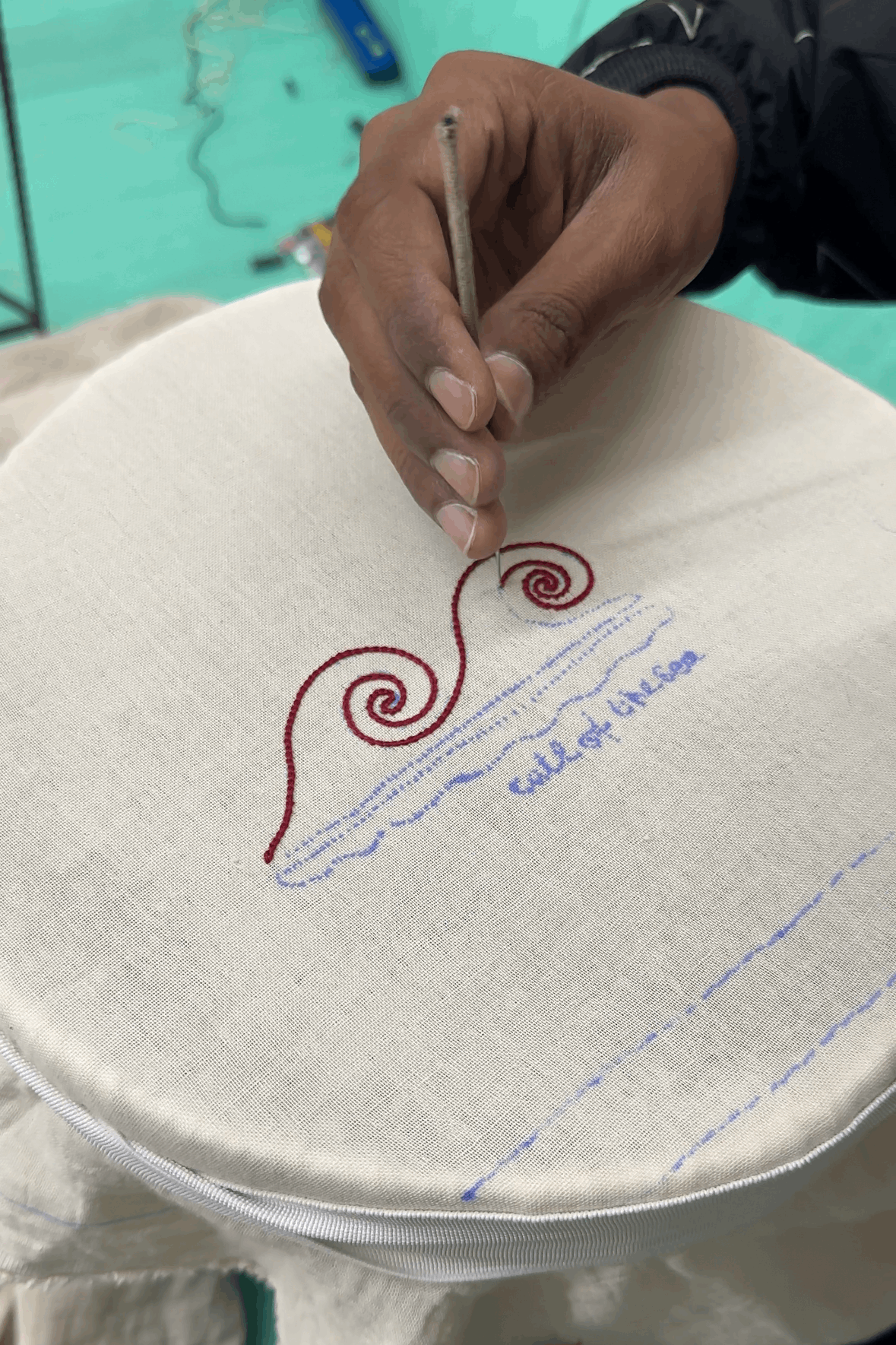 Artisan hand embroidering the wave motifs, the making of the Bora Bora Embroidered Shirt by Oje'