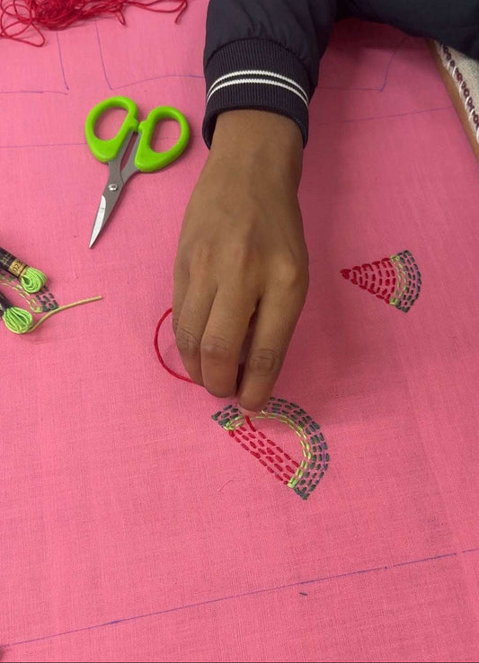 Artisan hand embroidering the watermelon motifs, the making of the Andaman Embroidered Shirt by Oje'