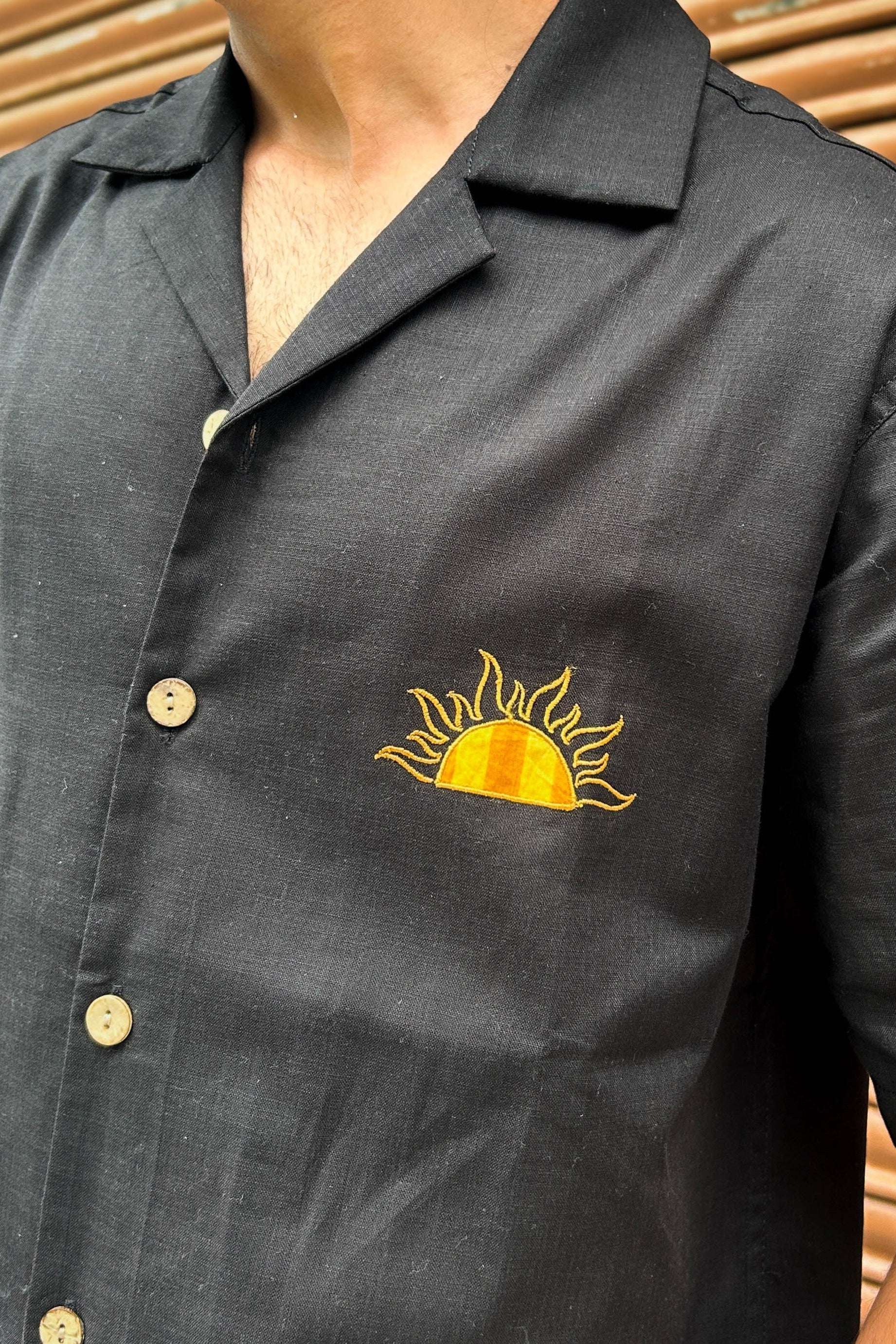 Close-up of the embroidered sun on the chest, Black cotton men's shirt