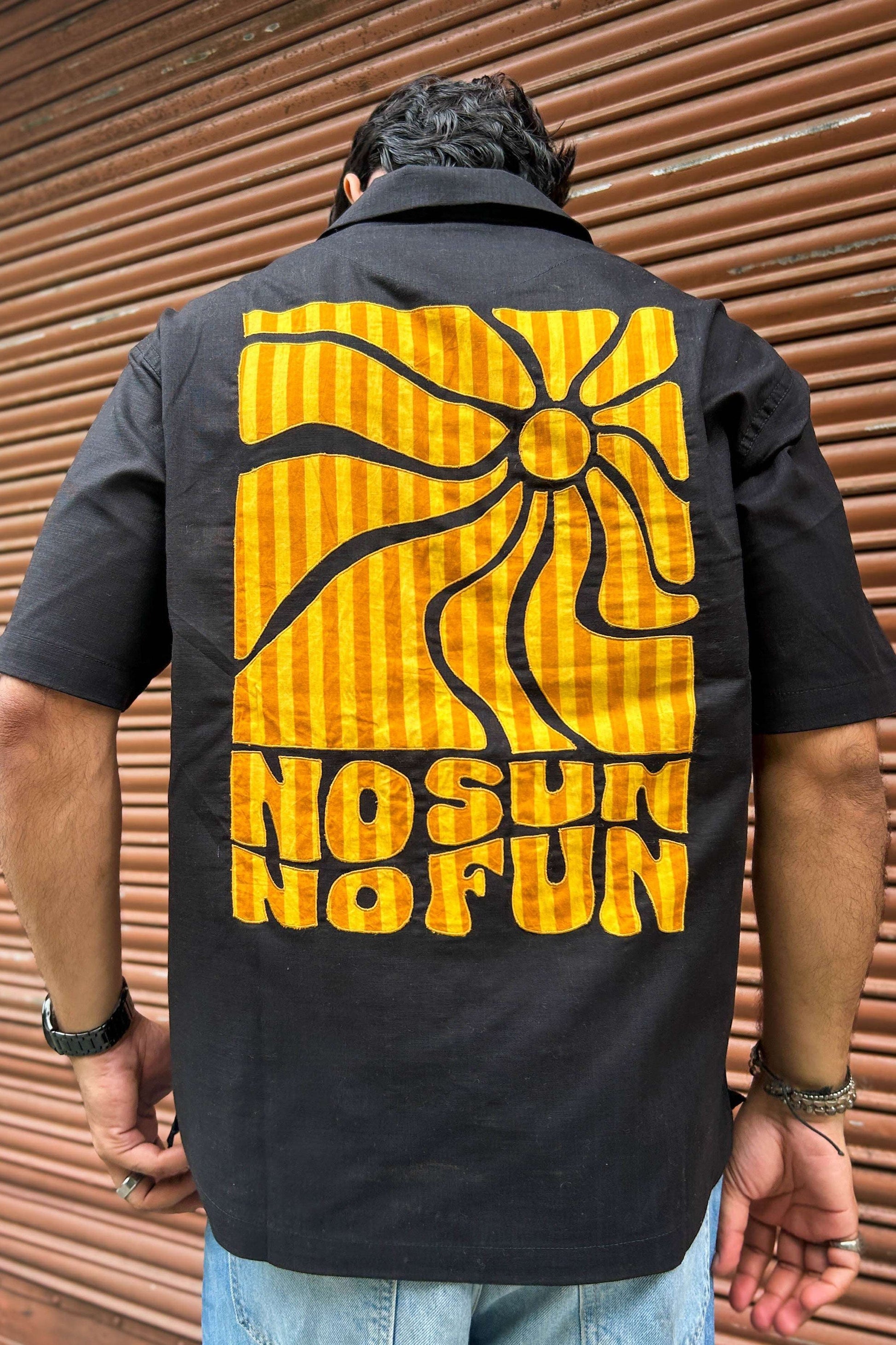 Close-up of the appliquéd sun and lettering on the back, Black cotton men's shirt