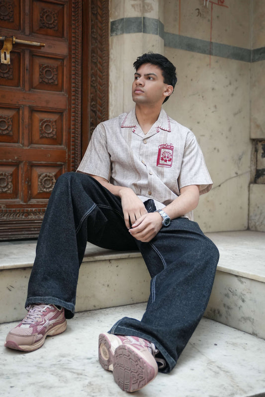 Sand beige cotton shirt for men with hand embroidered matchbox motif, seated view