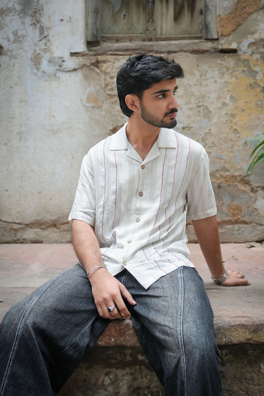 Ivory cotton viscose shirt for men with kantha hand embroidered stripes, seated three-quarter view