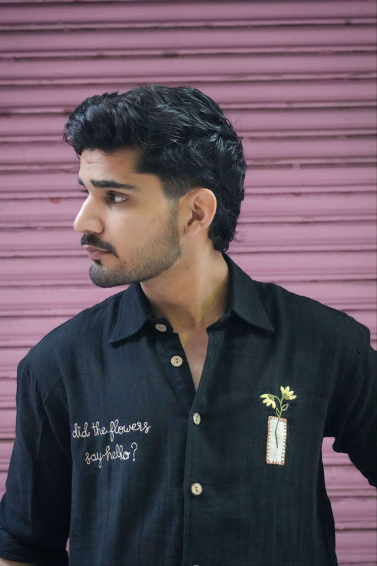 Black double cloth cotton shirt for men with hand embroidered text and flower vase, three-quarter view
