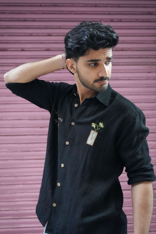 Black double cloth cotton shirt for men with hand embroidered text and flower vase, three-quarter view
