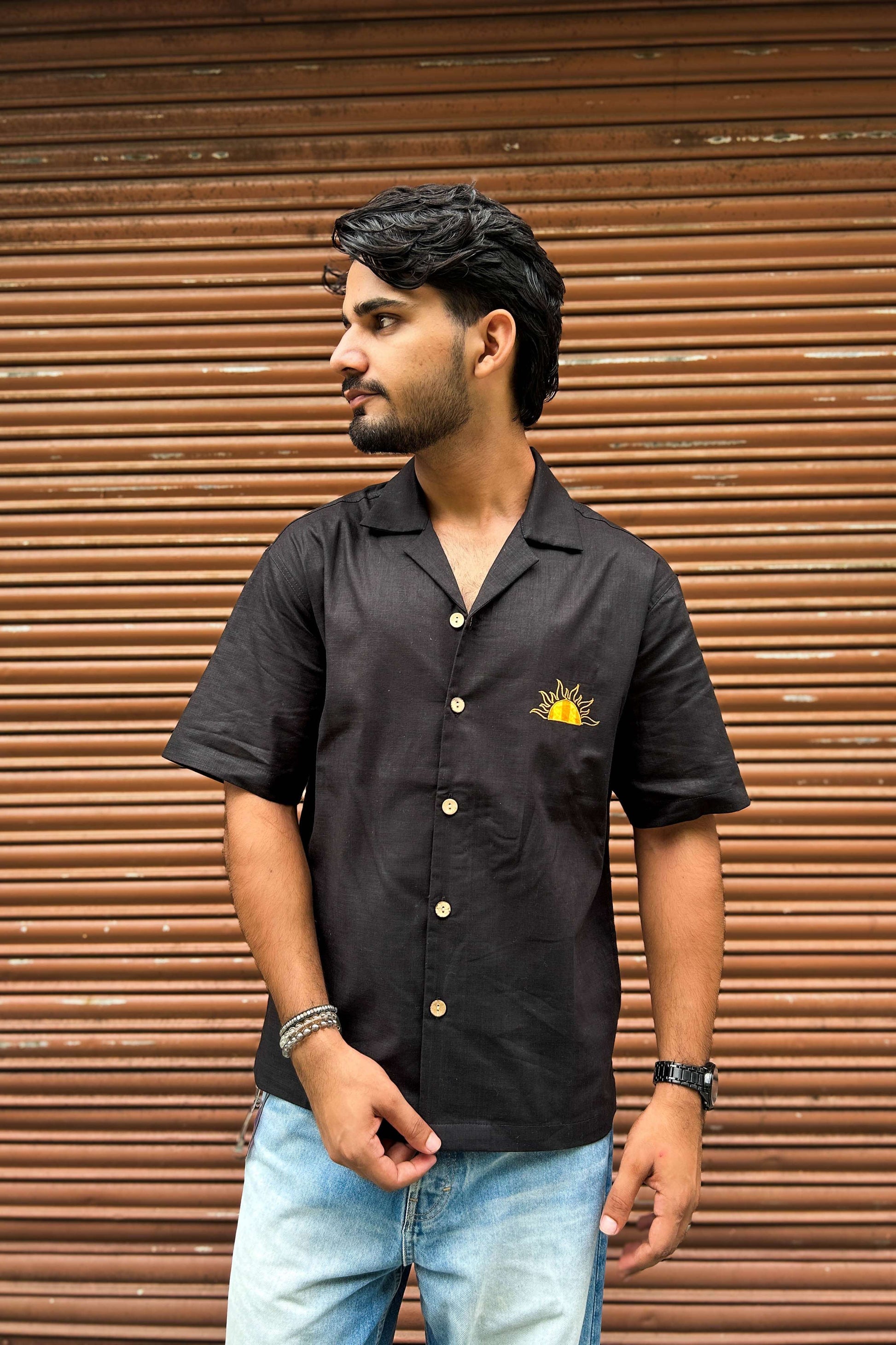 Black cotton shirt for men with appliquéd sun motif on the back, three-quarter view