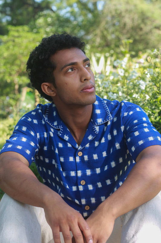 Royal blue ikat handloom cotton shirt for men with hand embroidered collar detail, seated view